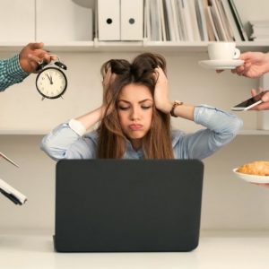 Webdesign Göttingen. Verzweifelte Frau im Arbeitsstress greift sich an den Kopf und weiss nicht was sie zuerst machen soll.